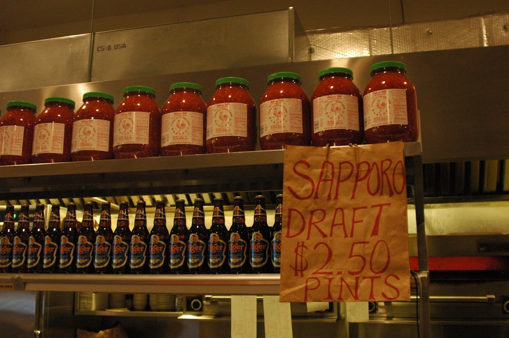 bottles of hot sauce on a shelf in a kitchen