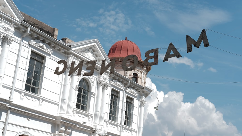 a large white building with a red dome on top