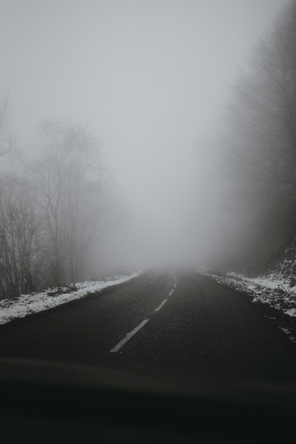 a black and white photo of a foggy road