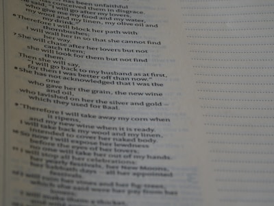 A close-up of a page from a book featuring text with religious or poetic content. The text is presented in a clear, serif font, and the page has a light beige background. The text includes verse numbers and appears to be structured in poetic lines.