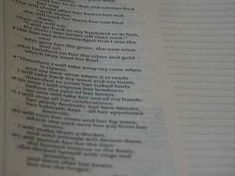 A close-up view of a page with religious text. The content includes verses and appears to be from a book or scripture, with neatly formatted lines and a structured layout.