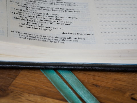 Open book of spiritual text resting on a rustic wooden table