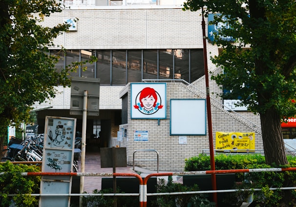 a brick building with a sign and trees in front of it