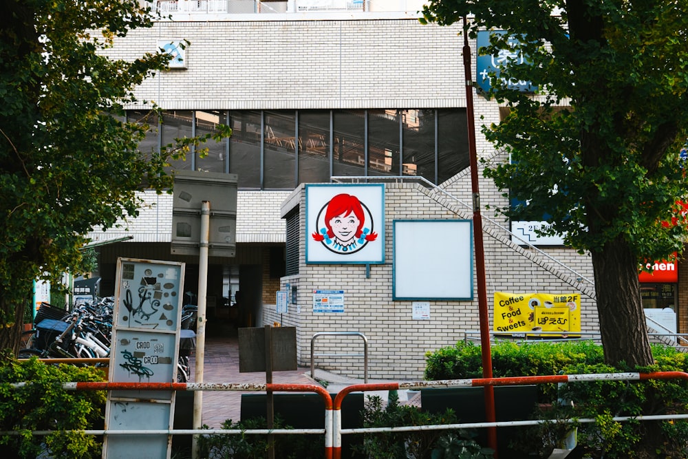 a brick building with a sign and trees in front of it