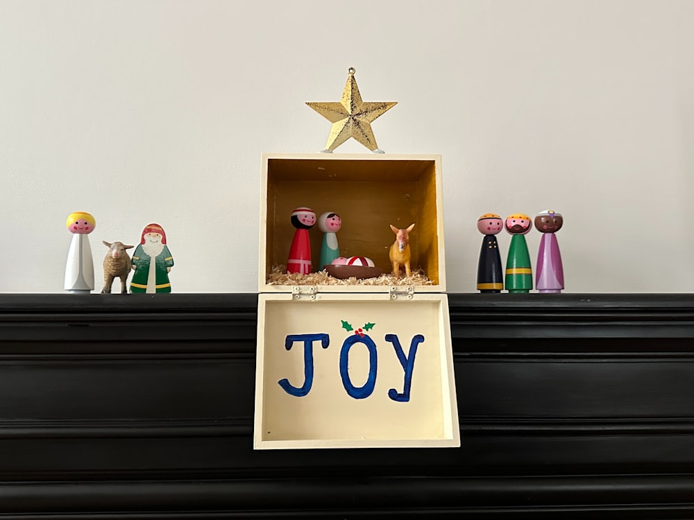 a nativity scene with a star on top of a mantel