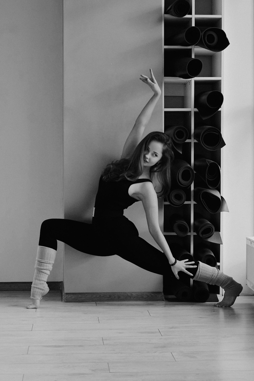 a woman leaning against a wall with her legs up