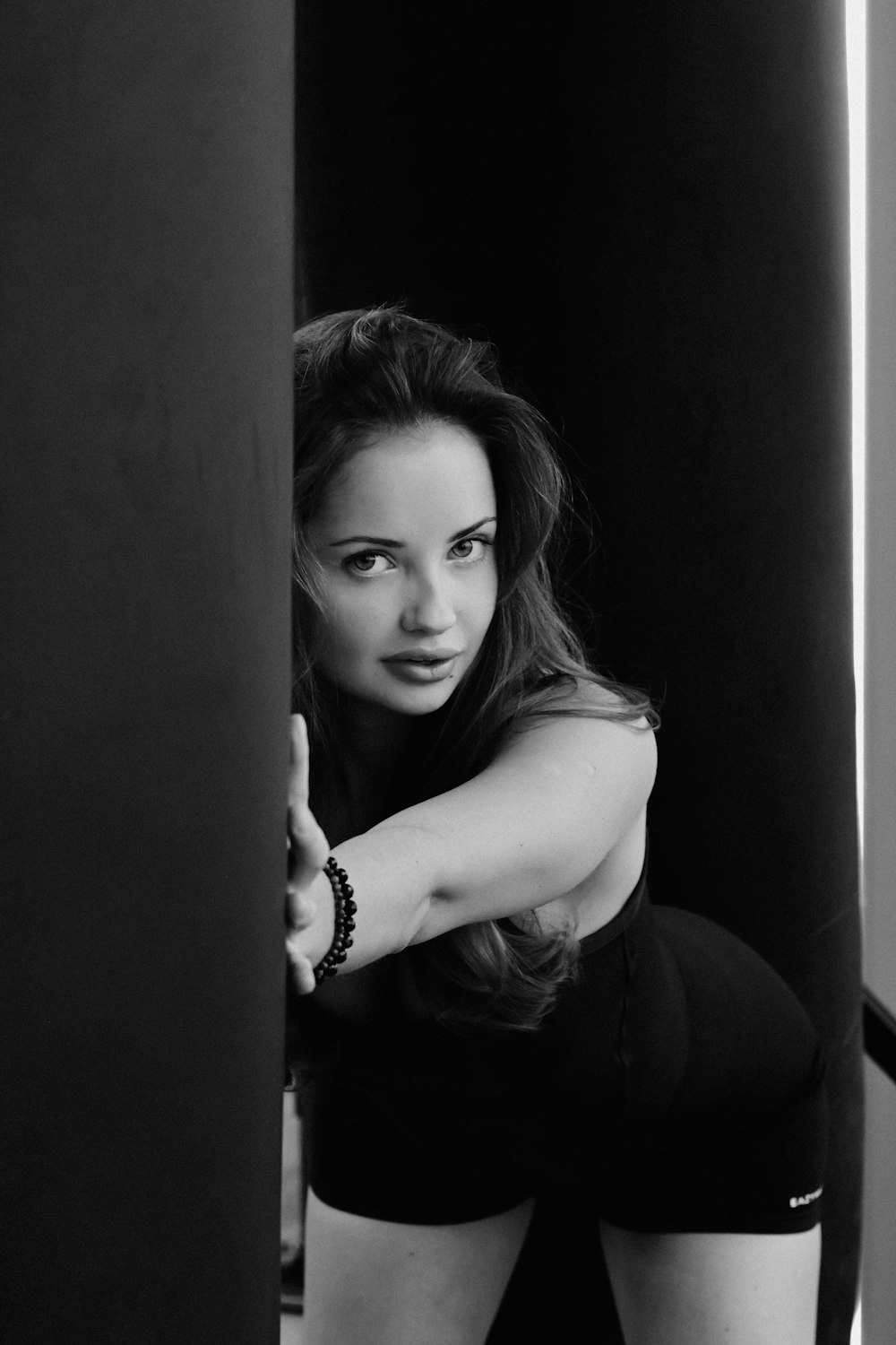 a woman leaning against a wall with her arms crossed