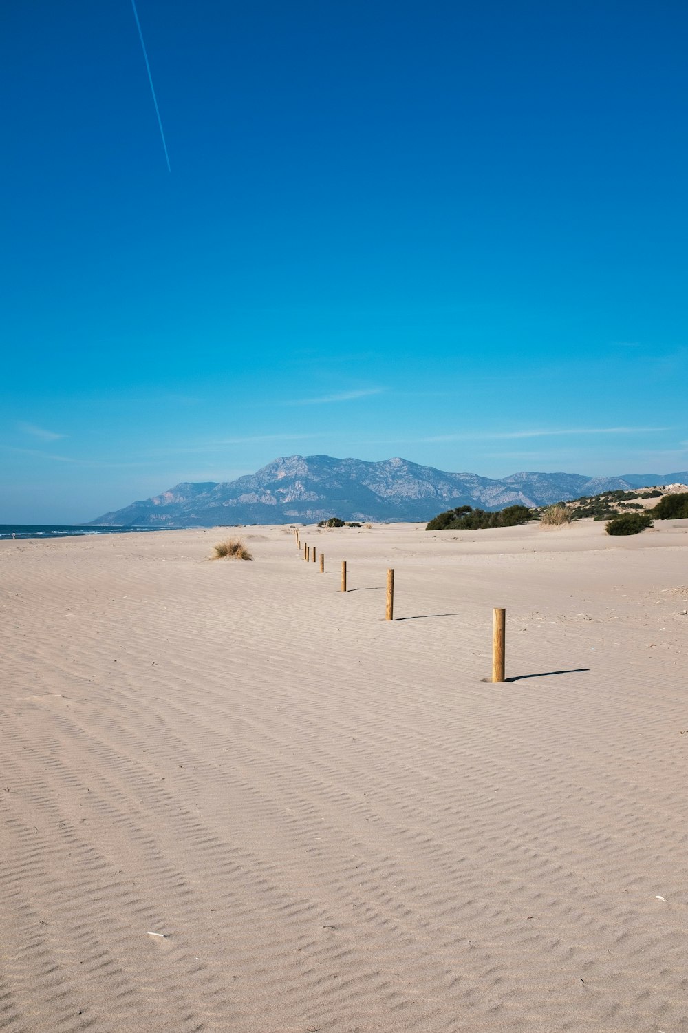 a sandy beach with mountains in the distance