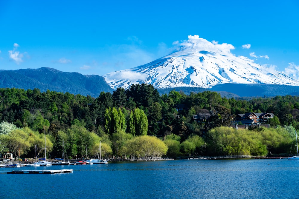 a lake with boats and a mountain in the background