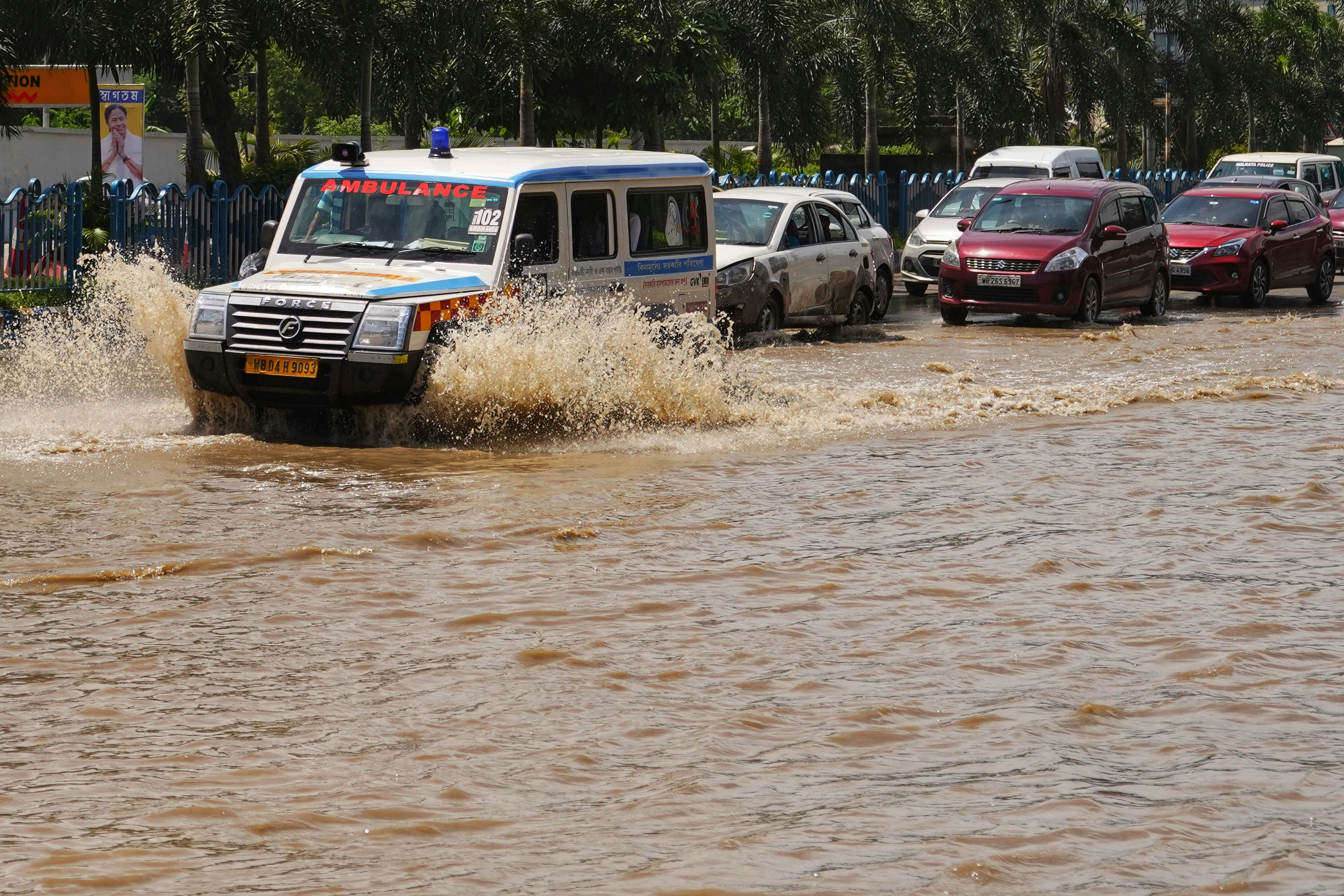 A group of cars driving through a flooded street photo – Free Water ...
