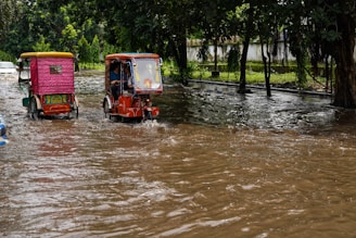 A tow truck assisting a flooded car on a rainy street in Hatyai.