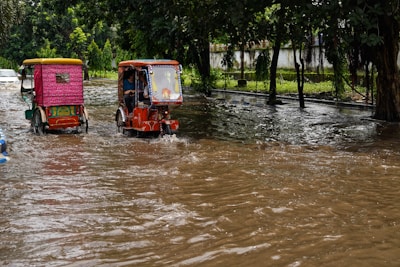 A tow truck assisting a flooded car on a rainy street in Hatyai.