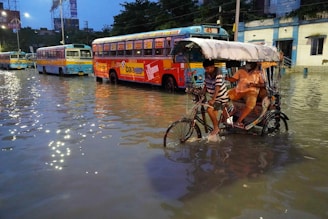 Boat taxi navigating through flooded urban streets with passengers onboard.