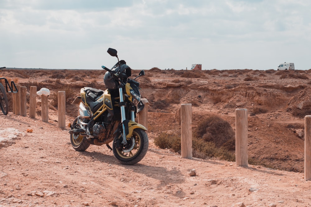 a motorcycle parked on the side of a dirt road