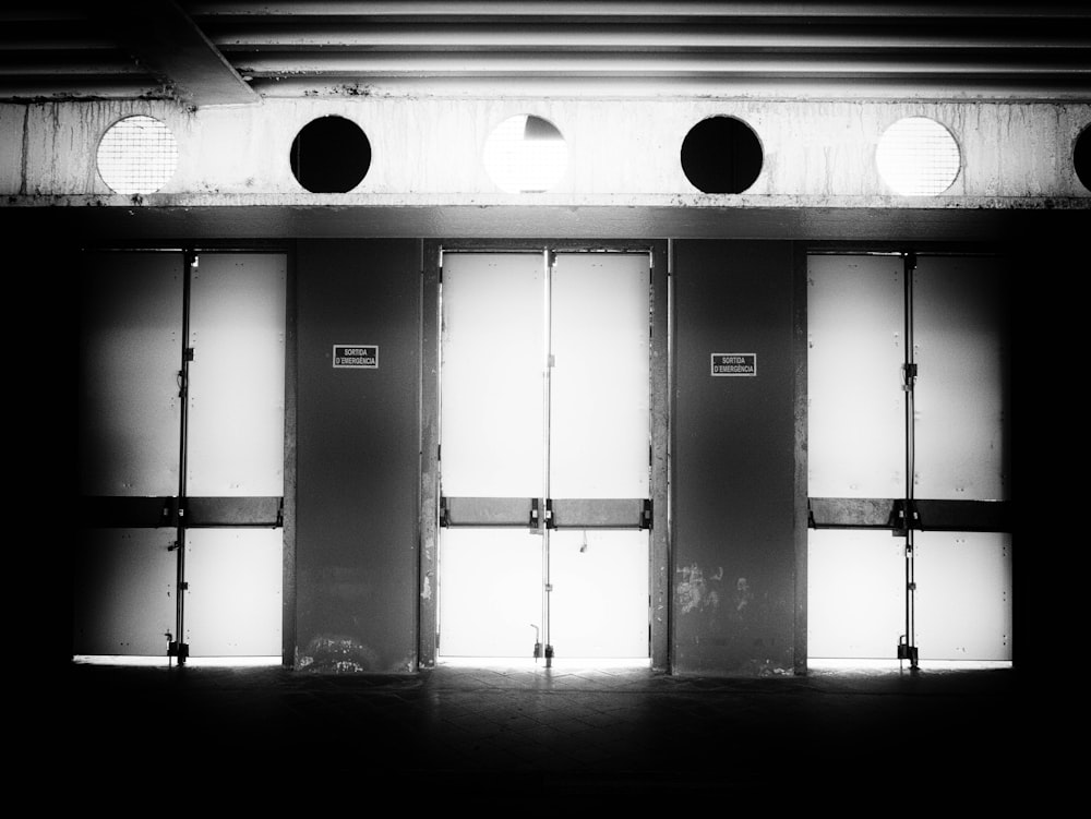a black and white photo of three doors