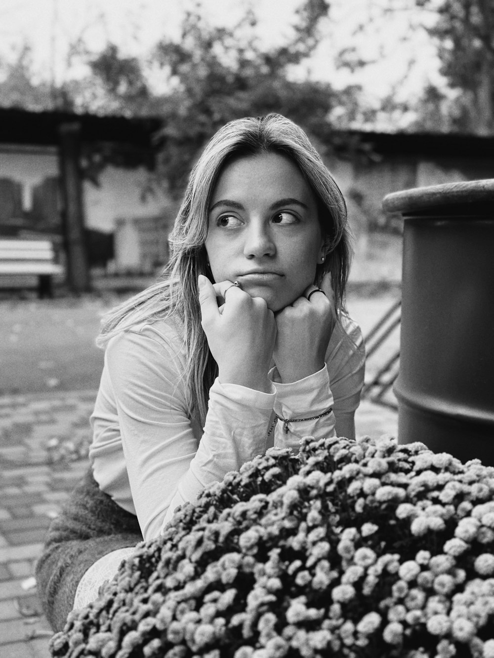 a black and white photo of a woman sitting on a bench