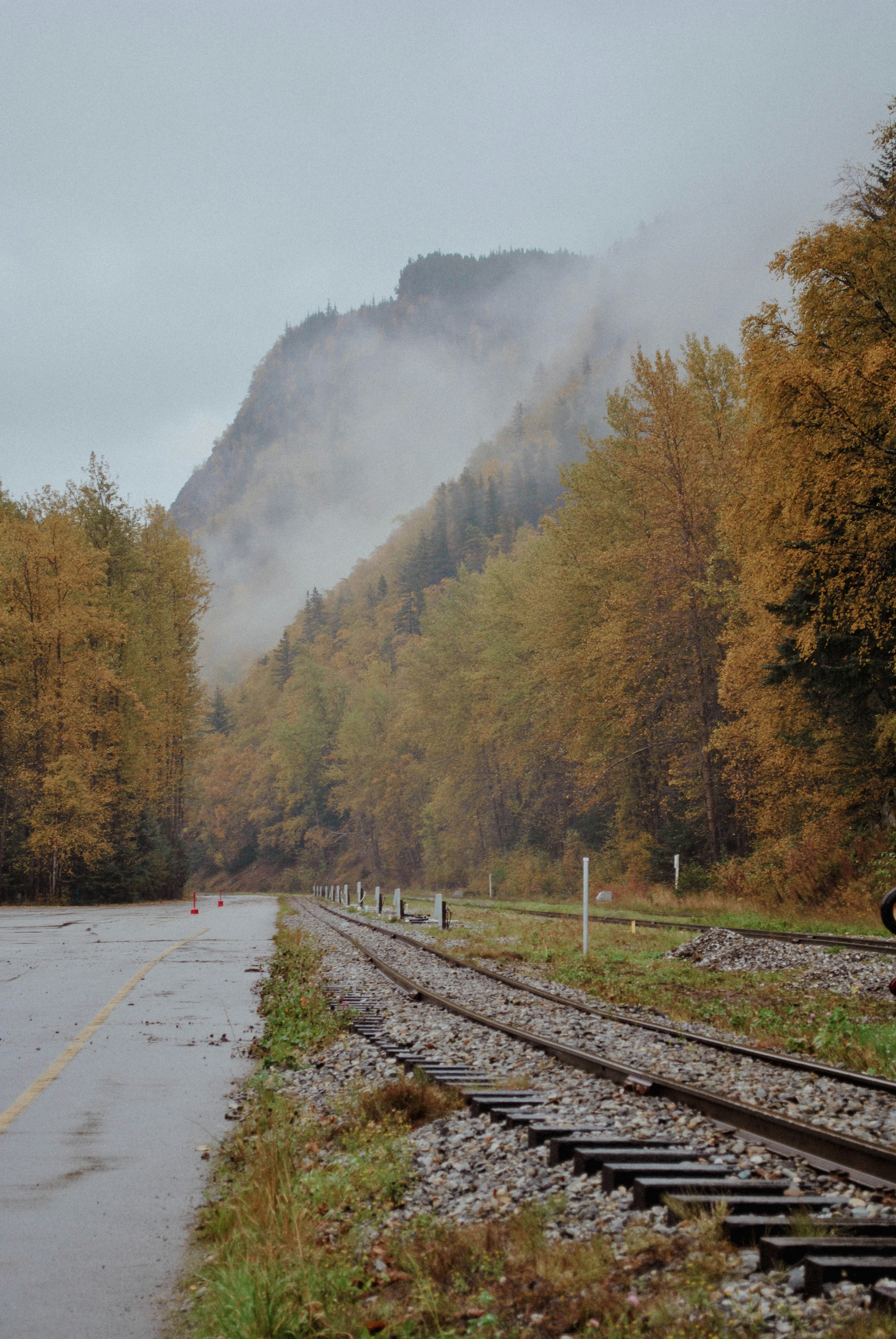 una vía de tren con una montaña al fondo