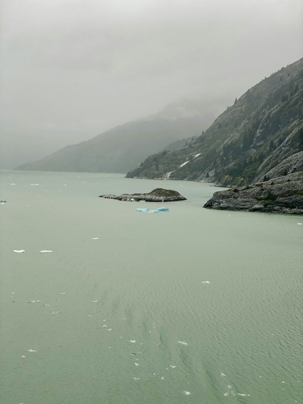 a large body of water with a mountain in the background