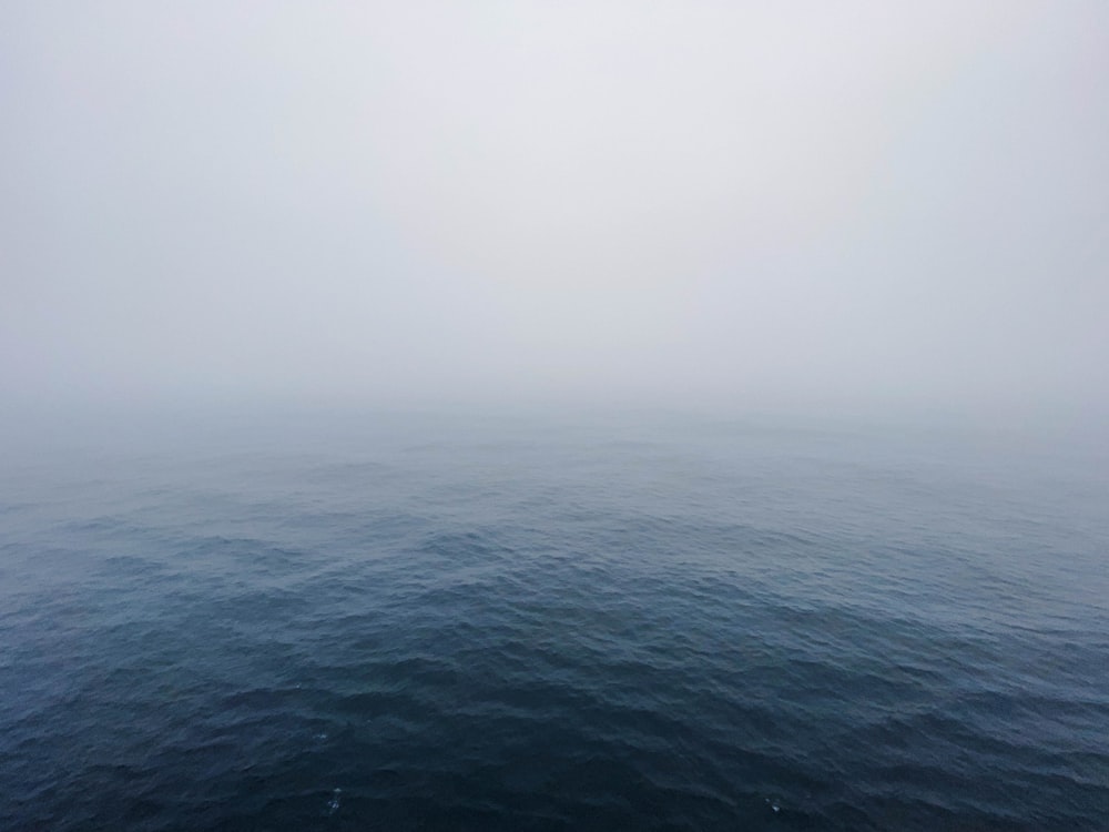 a large body of water surrounded by fog