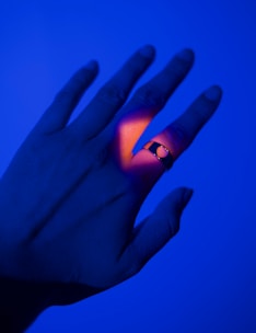 Close-up of the Lumina Ring glowing softly on a finger in natural light.