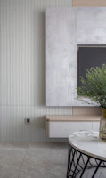 A cozy living room featuring a sleek TV wall with rounded corners and subtle wood accents.