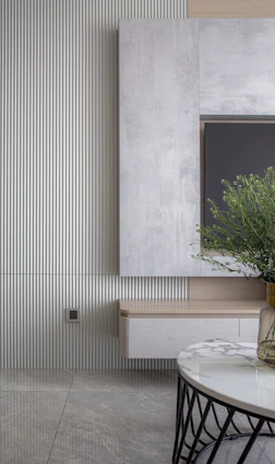 A sleek, modern living room showcasing custom cabinetry, marble accents, and warm brass lighting.