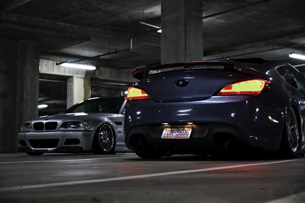 two cars parked in a parking garage next to each other