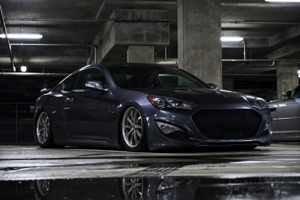 a car parked in a parking garage next to another car