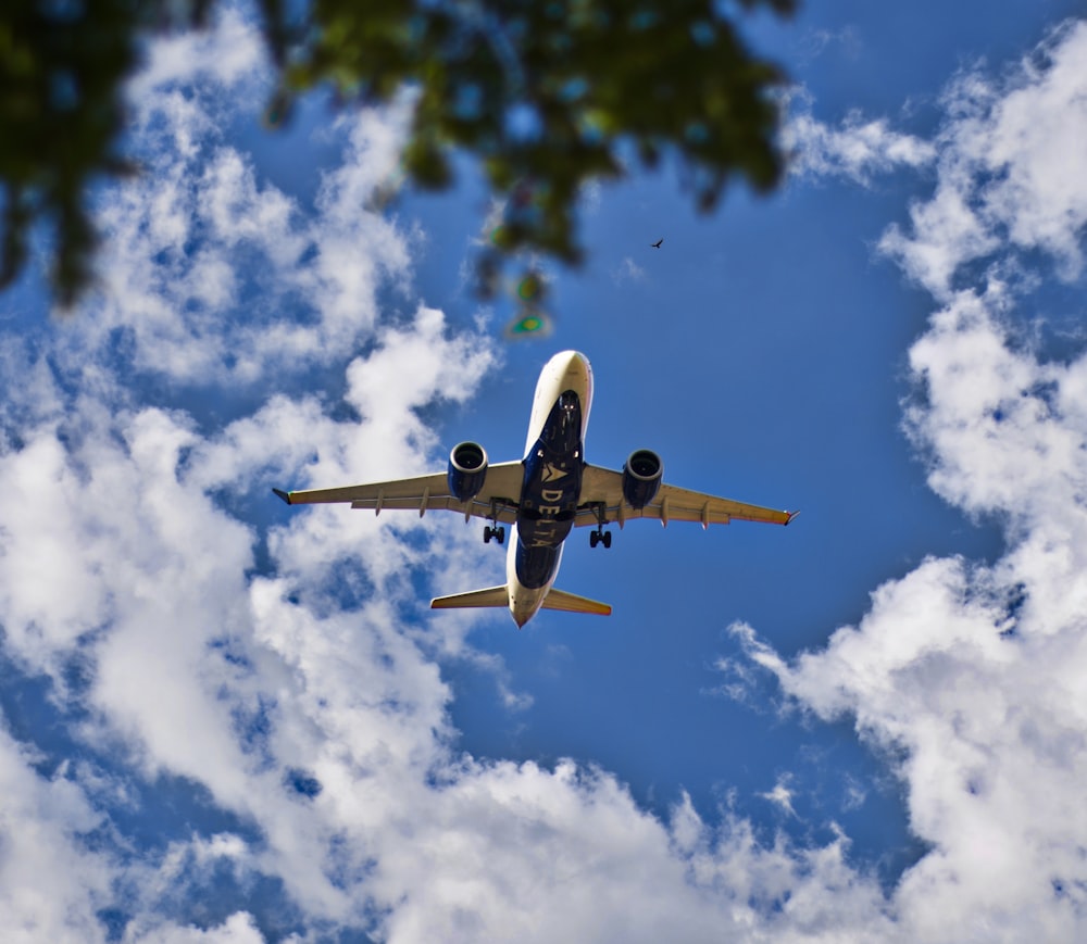 an airplane flying in the sky with clouds in the background