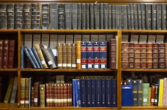 a bookshelf filled with lots of books on top of wooden shelves