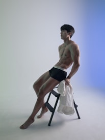 a man sitting on a stool posing for a picture