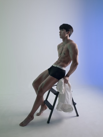 a man sitting on a stool posing for a picture