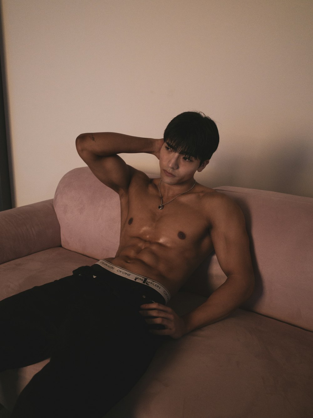 a shirtless young man sitting on a couch