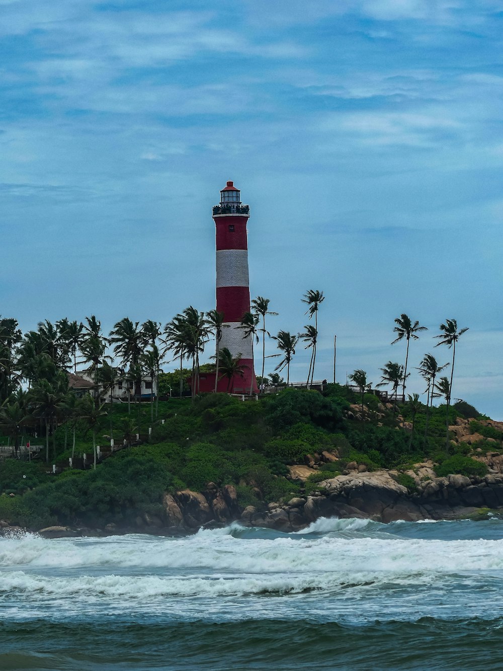 a red and white light house sitting on top of a small island