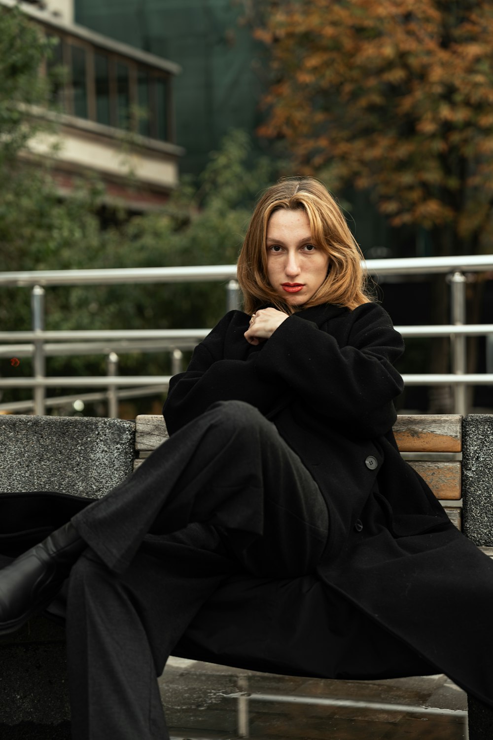 a woman sitting on top of a wooden bench