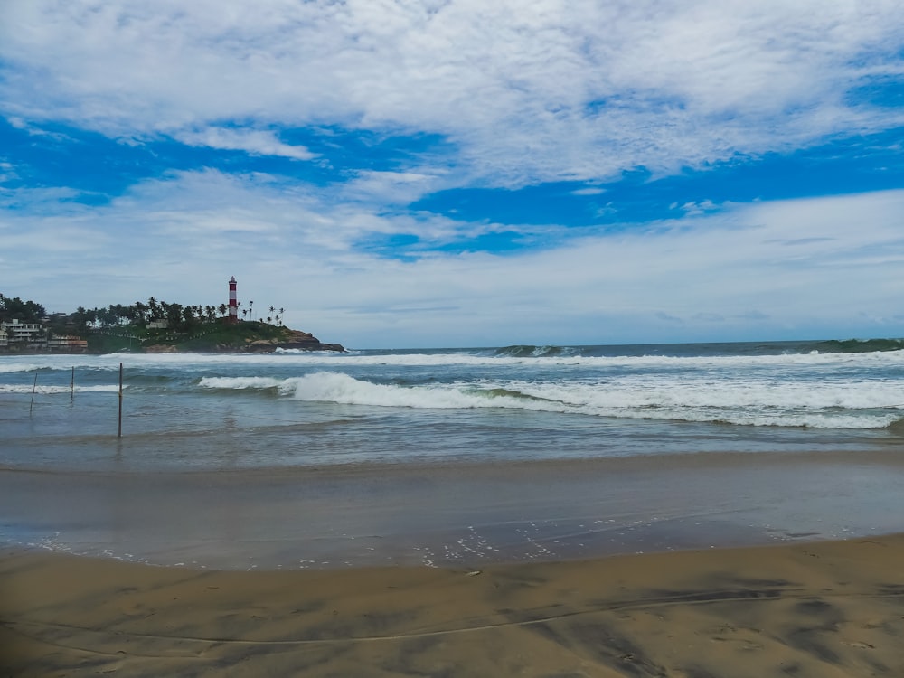 a view of a beach with a lighthouse in the distance