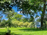 An exterior view of the rental property showcasing the detached carport and lush landscaping.