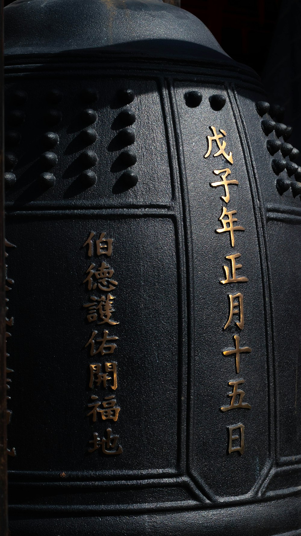 a close up of a black vase with writing on it