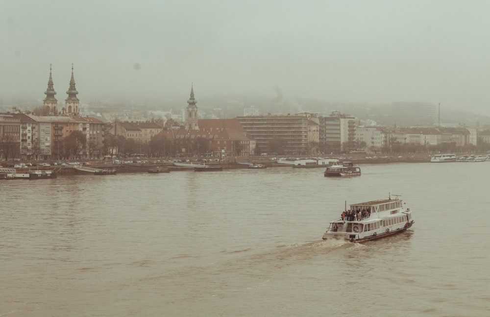 a boat traveling down a river next to tall buildings