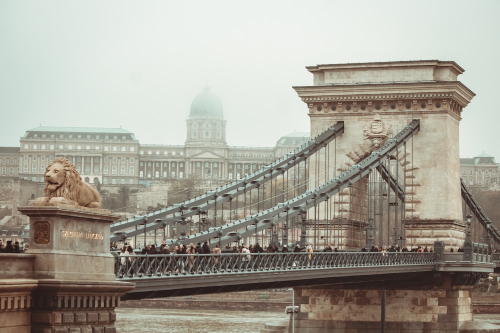 a group of people walking across a bridge