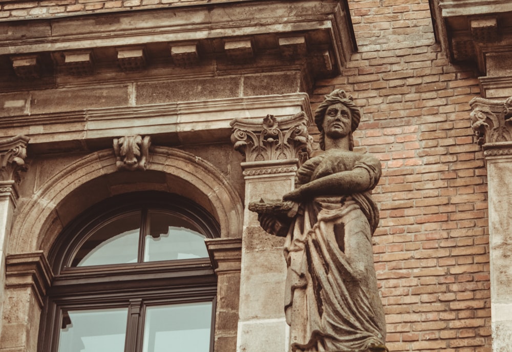 a statue of a woman standing in front of a building