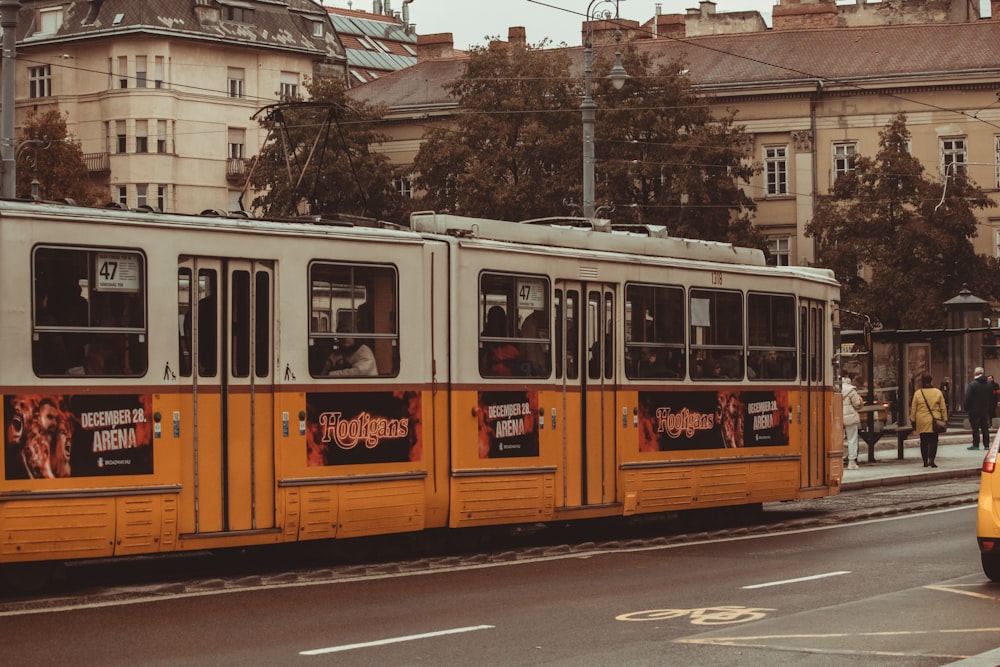 a trolley car on a city street with buildings in the background