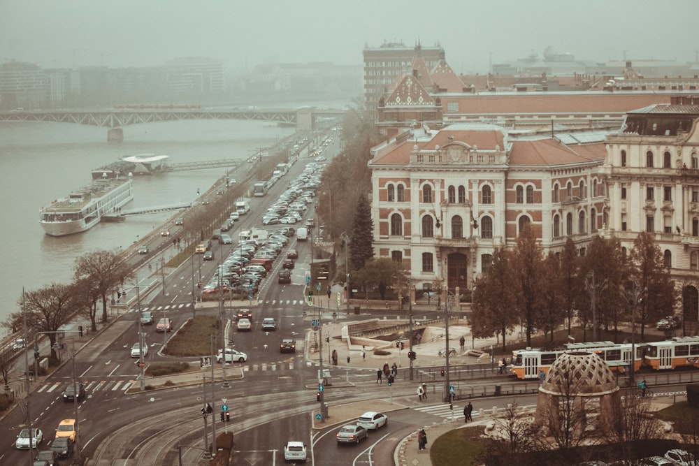 a city street filled with lots of traffic next to a river