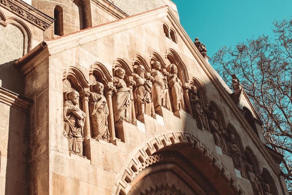 a tall building with statues on the side of it