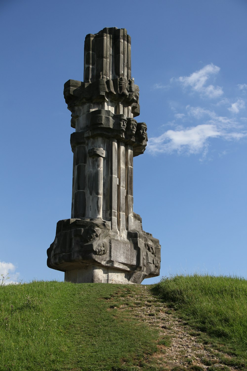 a tall stone structure sitting on top of a lush green field