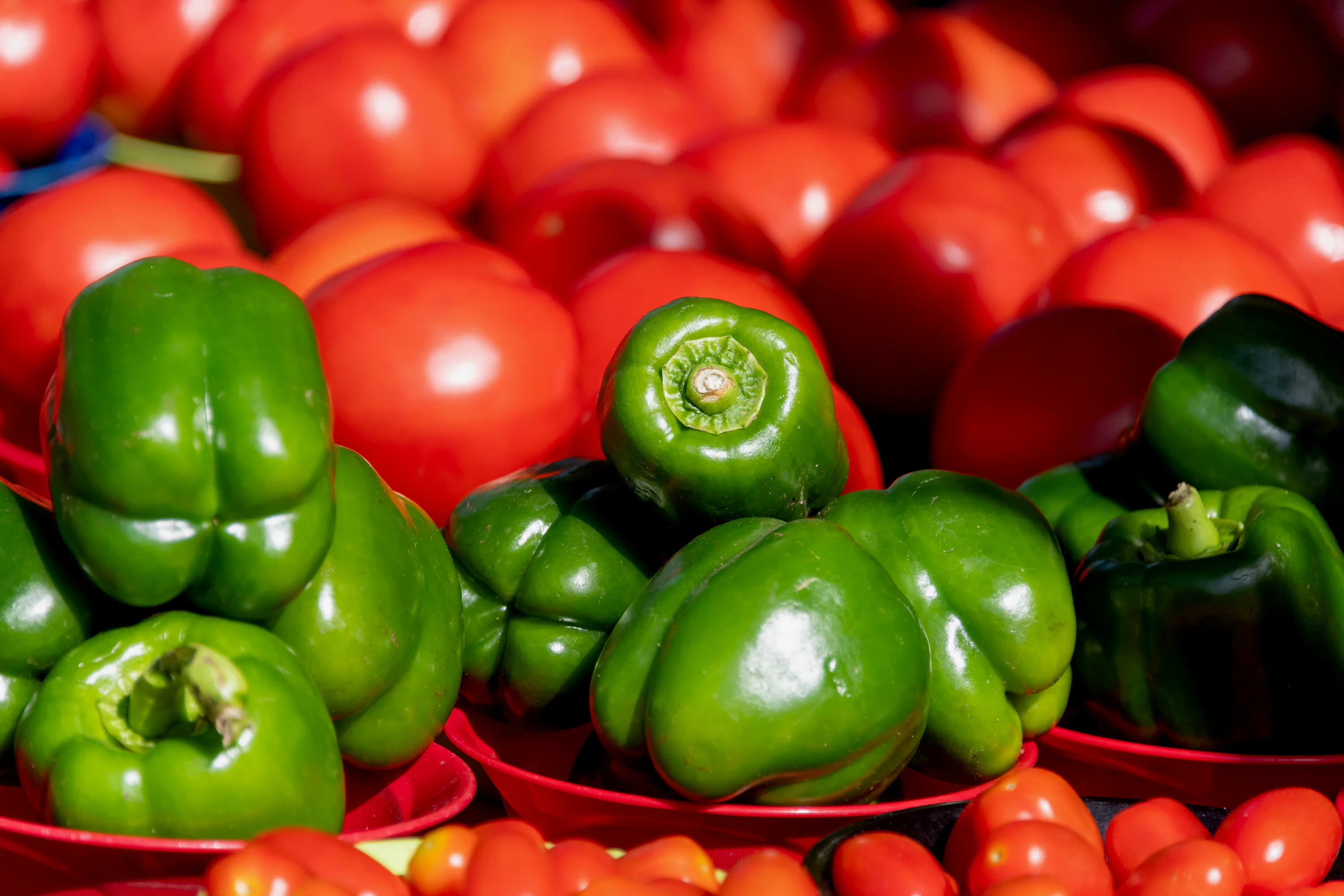 a pile of red and green peppers and tomatoes