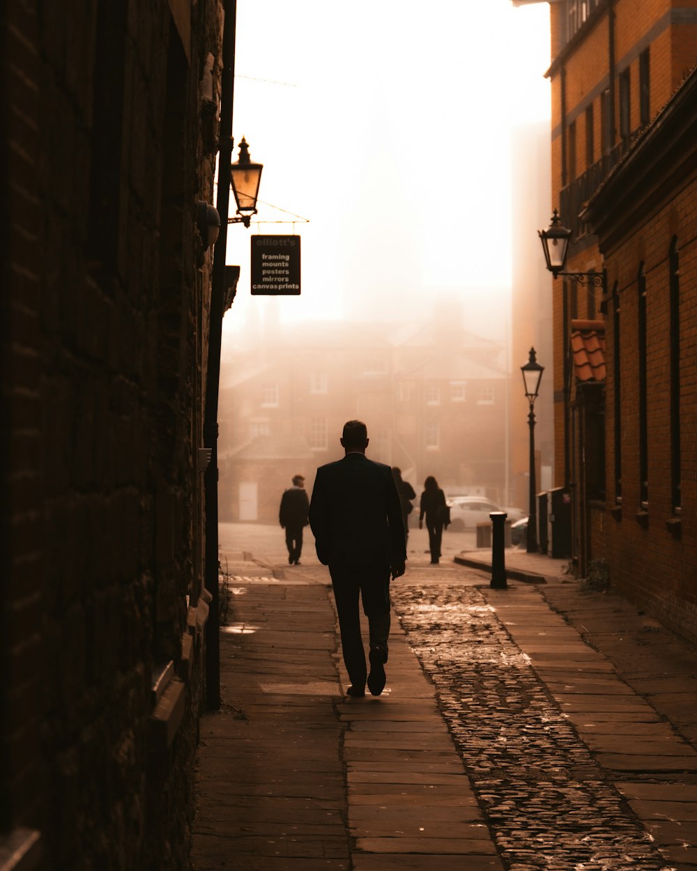 a man walking down a street next to tall buildings