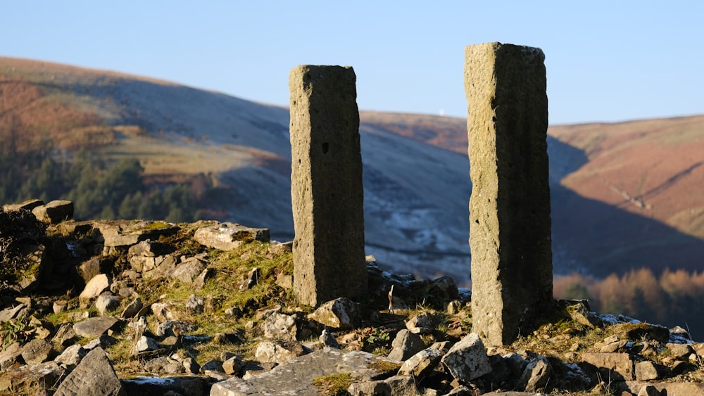 a couple of stone pillars sitting on top of a rocky hillside