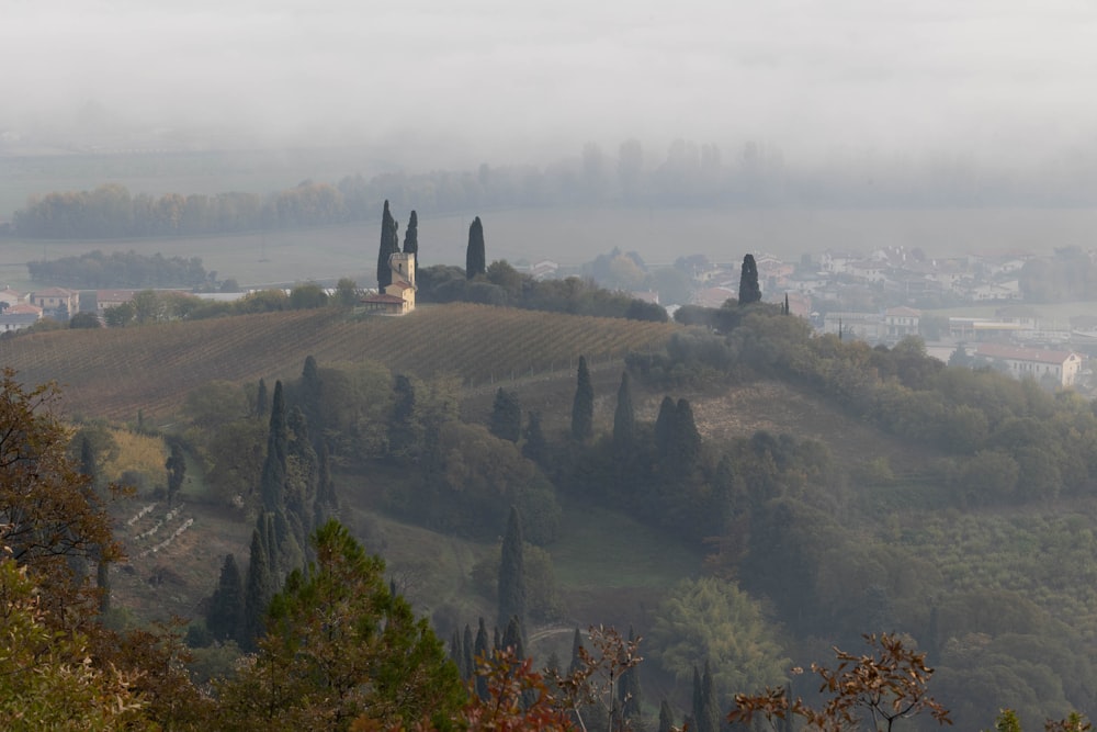 a foggy view of a small village on top of a hill