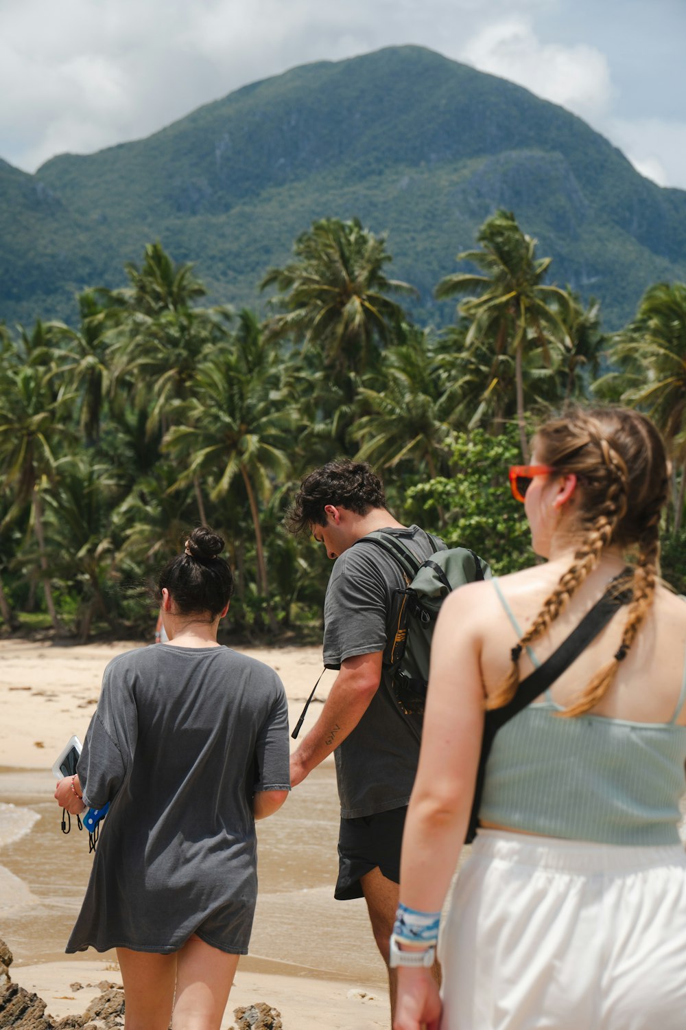 a group of people walking along a sandy beach